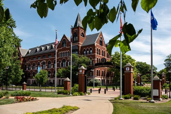 DuBourg Hall 在博彩网址大全, with a campus gateway and sidewalk